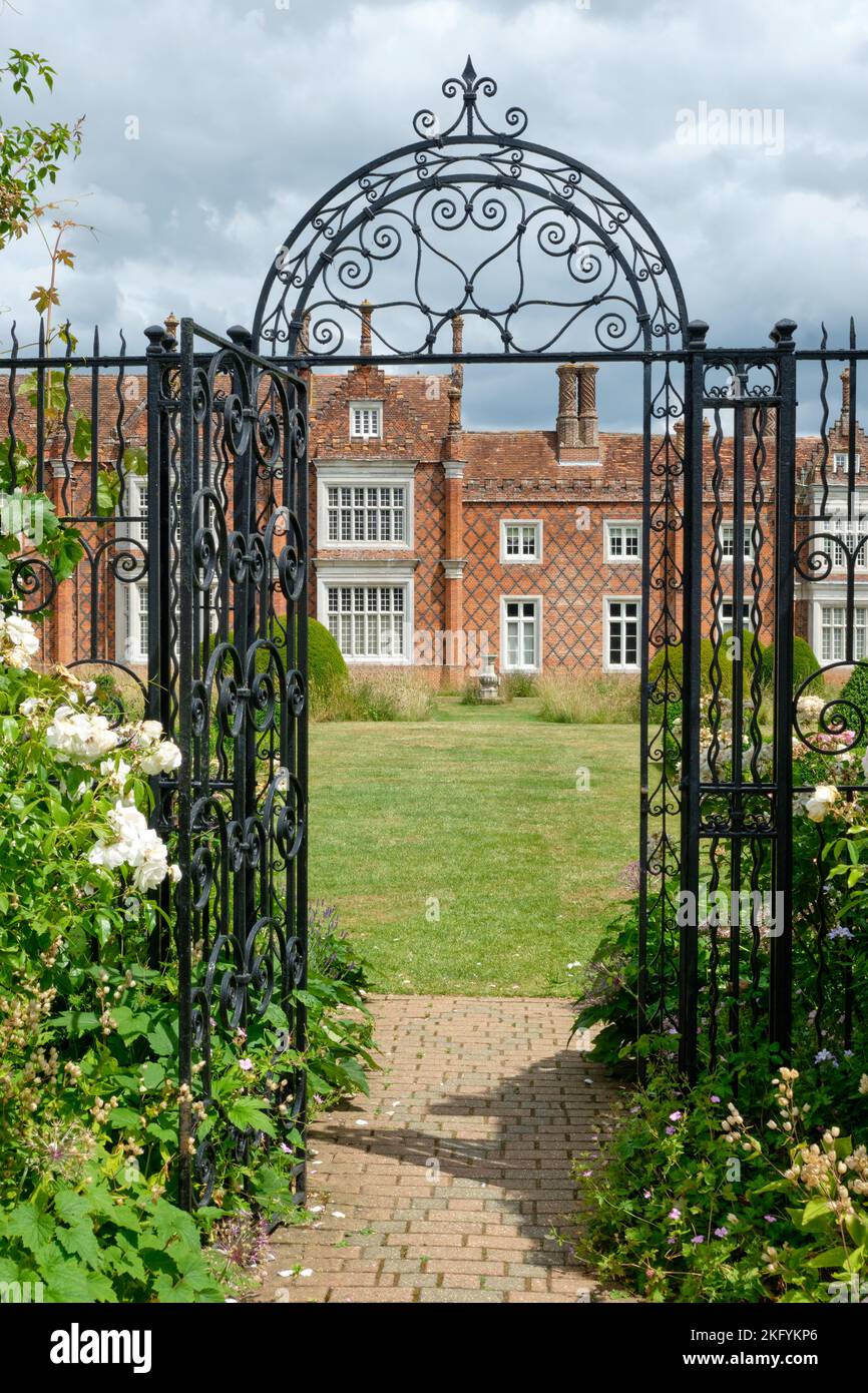 Summer Portrait view of  Ornate Metal gateway to herbaceous borders in Helmingham Hall and Gardens Suffolk Stock Photo
