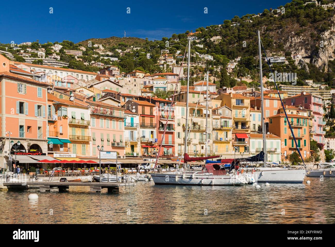 Colourful hotel and apartment building facades and harbour with moored sailboats and pleasure boats, Villefranche-sur-Mer, Provence, France. Stock Photo