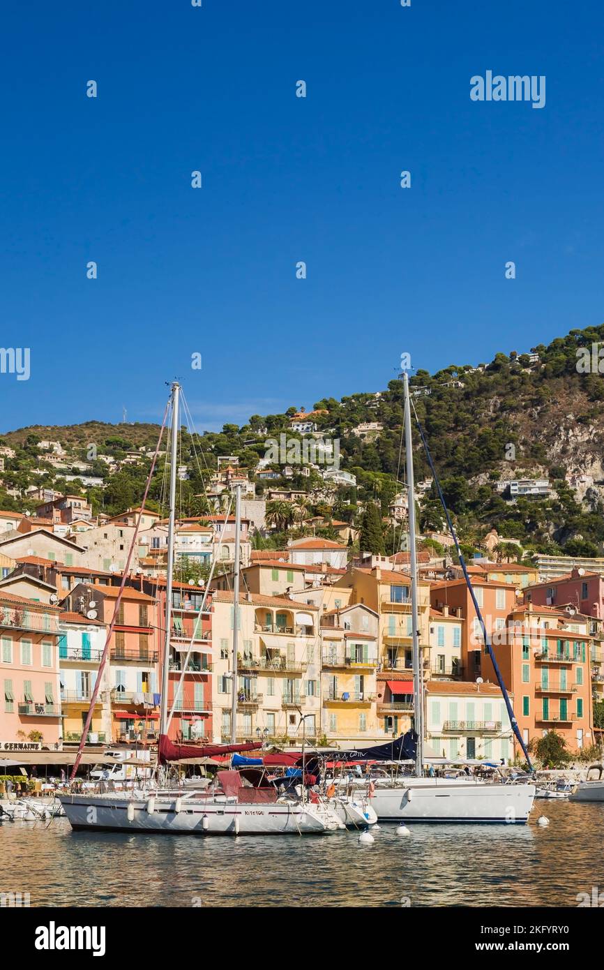 Colourful hotel and apartment building facades and harbour with moored sailboats and pleasure boats, Villefranche-sur-Mer, Provence, France. Stock Photo