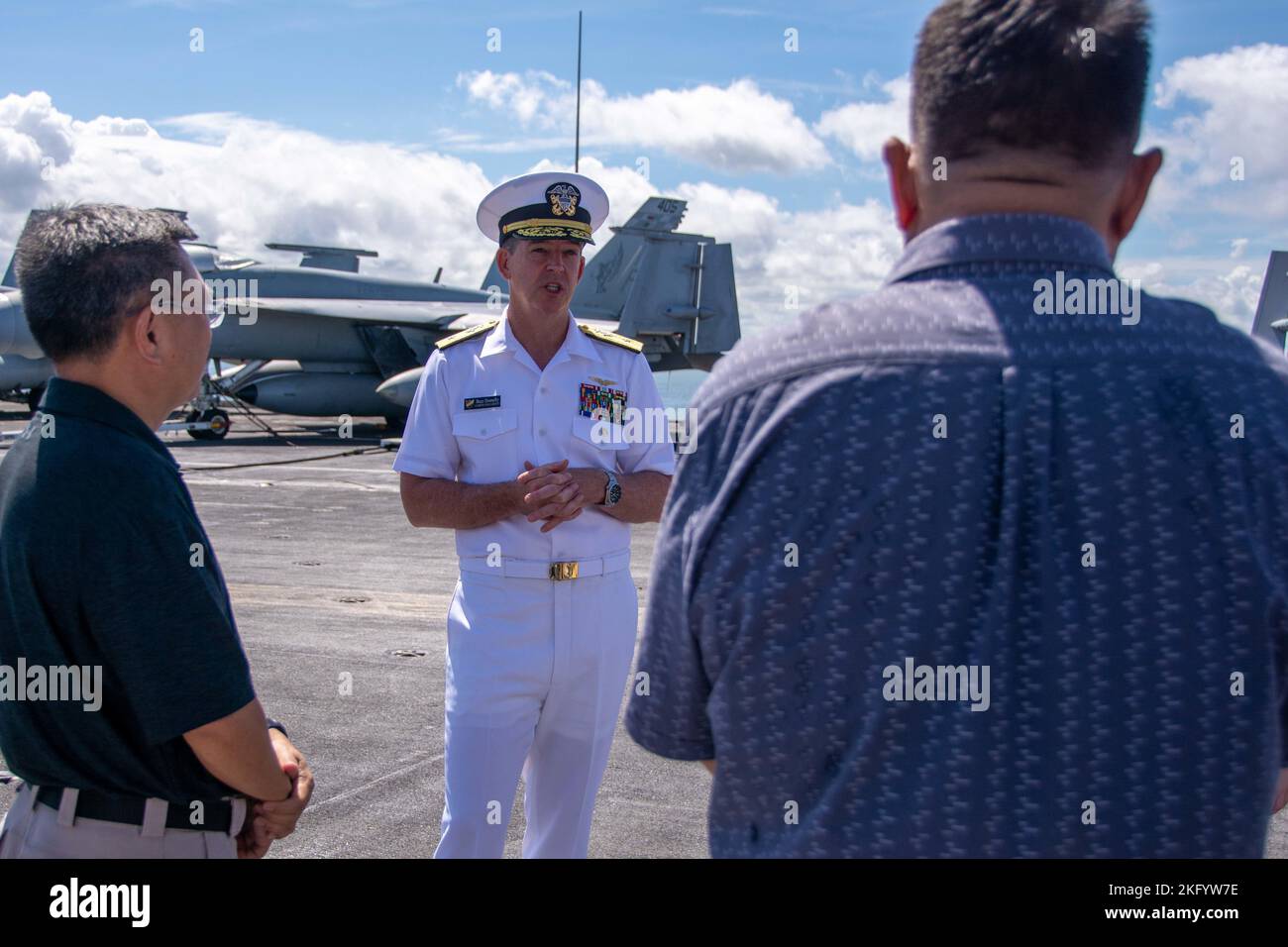 221015-N-RC359-1051 MANILA BAY (Oct. 15, 2022) Rear Adm. Buzz Donnelly, commander, Carrier Strike Group (CSG) 5 speaks with Mr. Augusto D. dela Pena, undersecretary for the department of environment and natural resources, left and Philippine Coast Guard Rear Adm. Charlie Rances, during a tour of the flight deck aboard the U.S. Navy’s only forward-deployed aircraft carrier USS Ronald Reagan (CVN 76) while at anchor in Manila Bay, Philippines, Oct. 15. Ronald Reagan, the flagship of CSG 5, provides a combat-ready force that protects and defends the United States, and supports alliances, partners Stock Photo