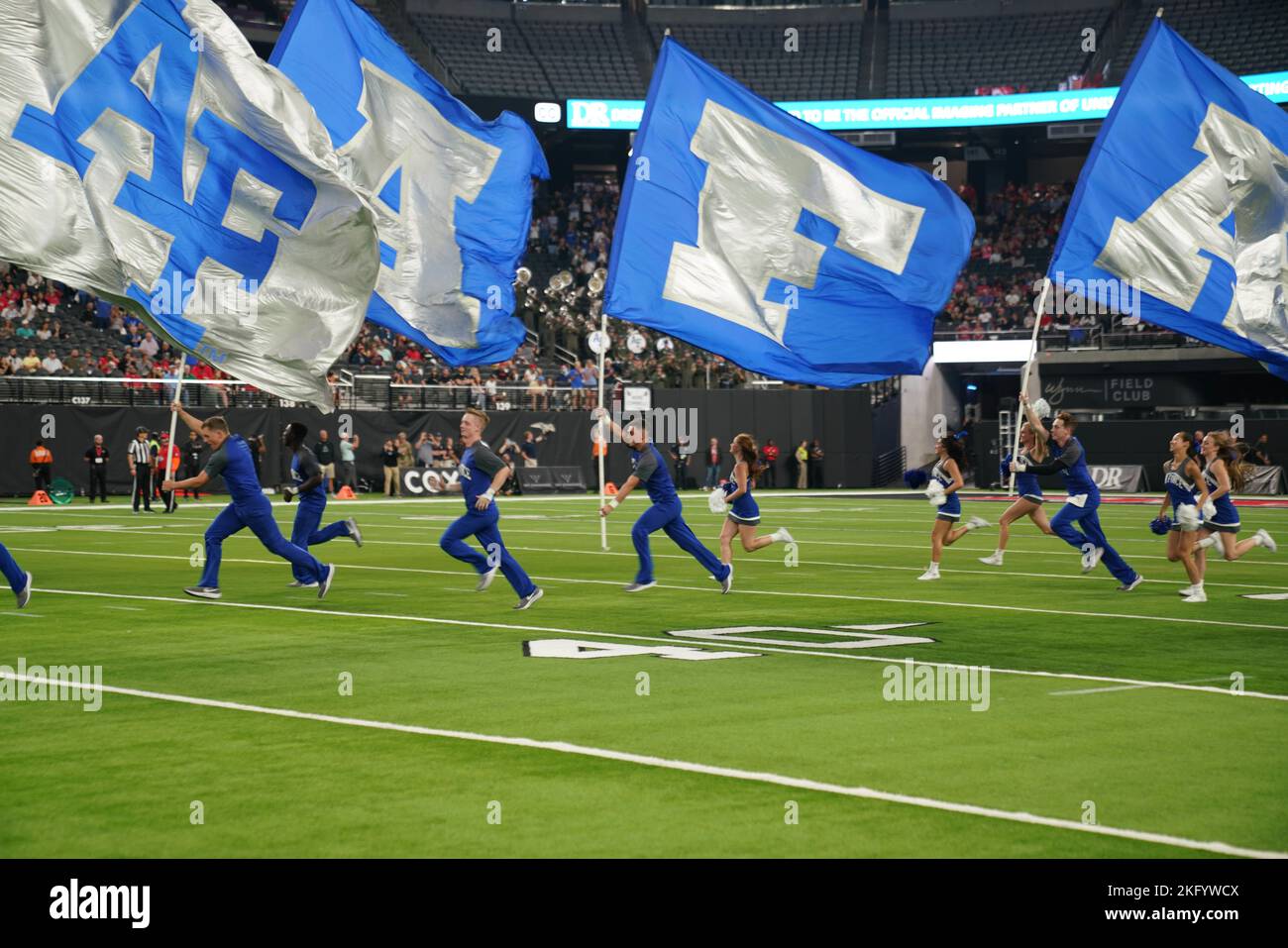 United States Air Force Academy cheerleaders run out on the field holding  spirit flags at Allegiant Stadium in Las Vegas, Nevada, Oct. 15, 2022. The Air  Force Academy competed in a football