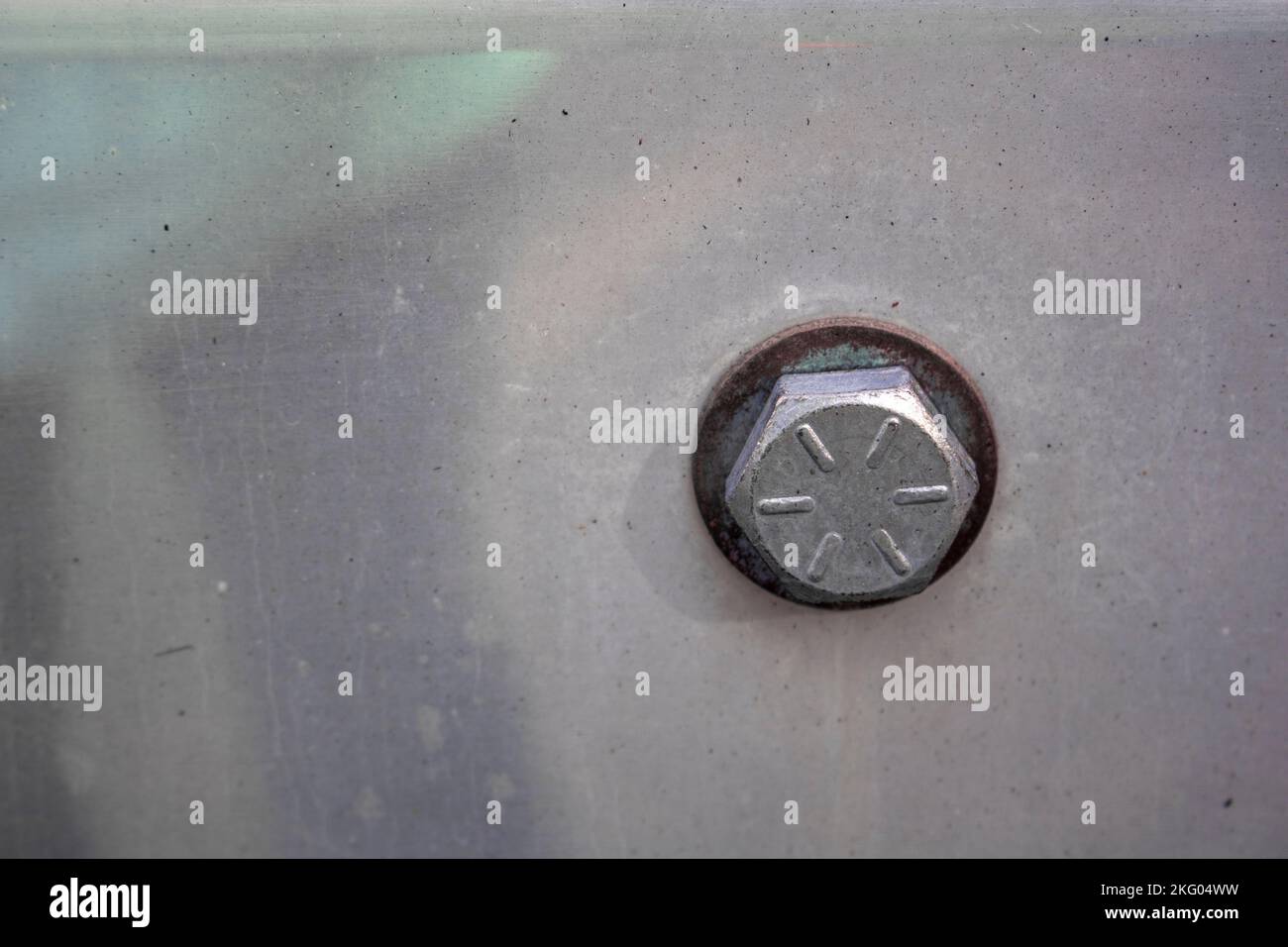 The Head of a bolt bolted on a steel metal plate with a washer in between Stock Photo