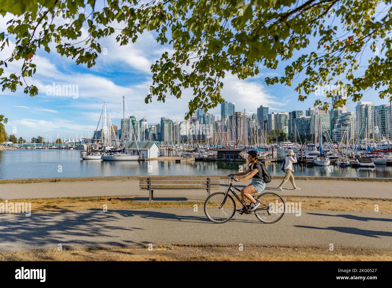 Vancouver, British Columbia, Canada in summer day. Unidentified tourists and bicyclists at Stanley Park and Vancouver Skyline with marina-October 3,20 Stock Photo