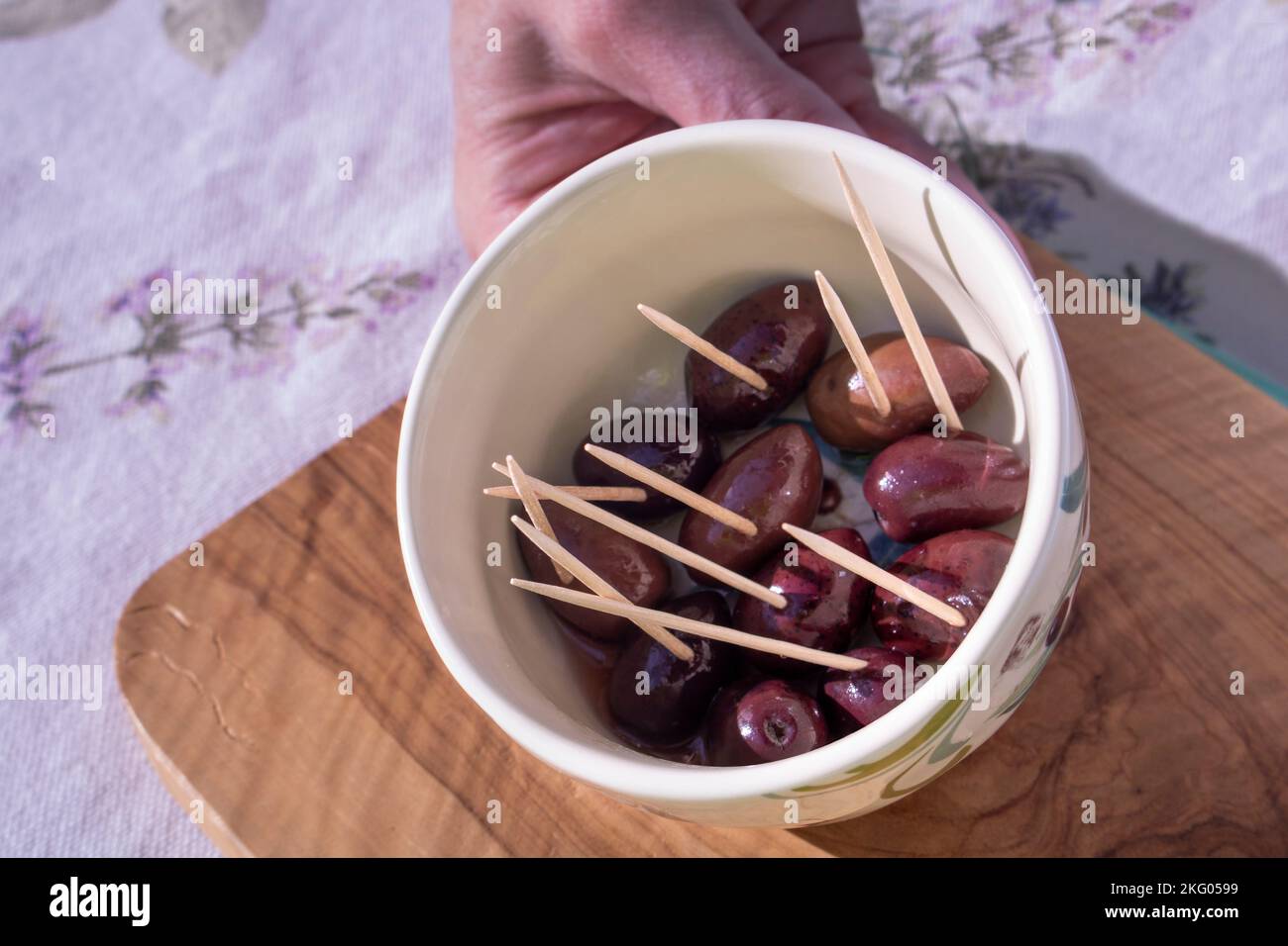 serving up a sample of Castelvetrano olives with wood toothpicks in a ...