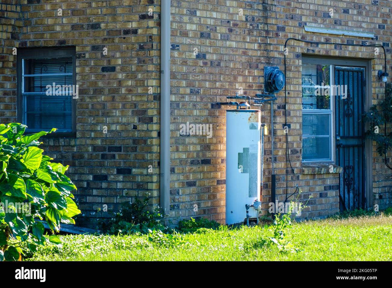 NEW ORLEANS, LA, USA - NOVEMBER 13, 2022: Exposed conventional water heater, with sunlight reflection, on exterior of residential building. Stock Photo