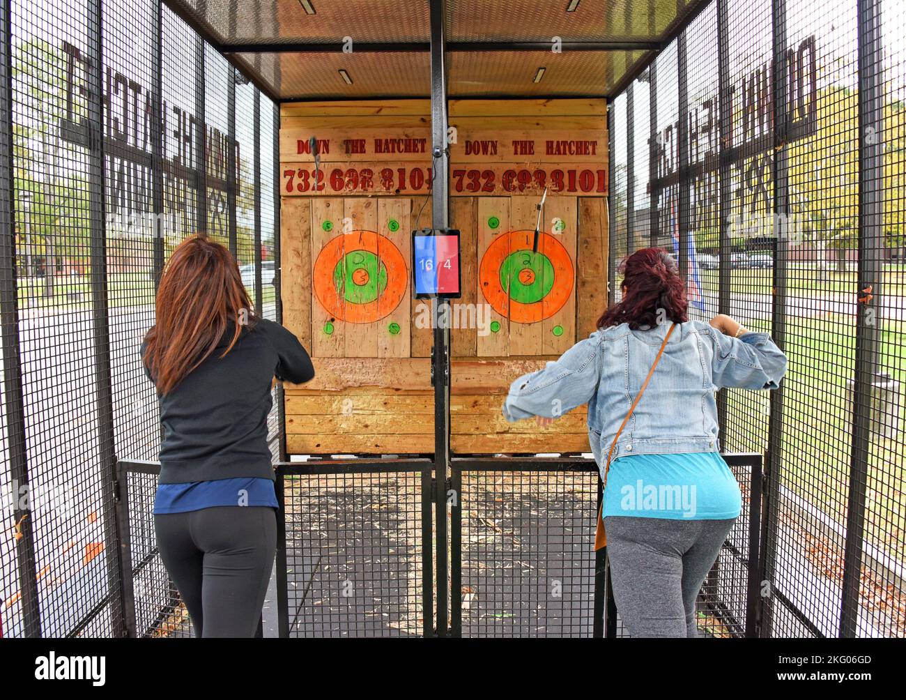 Participants throw hatchets at wooden targets inside the arena, outside