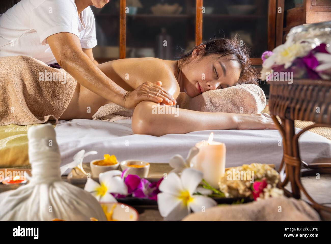 Woman relaxing while get oil massage at thai traditional spa salon. Stock Photo