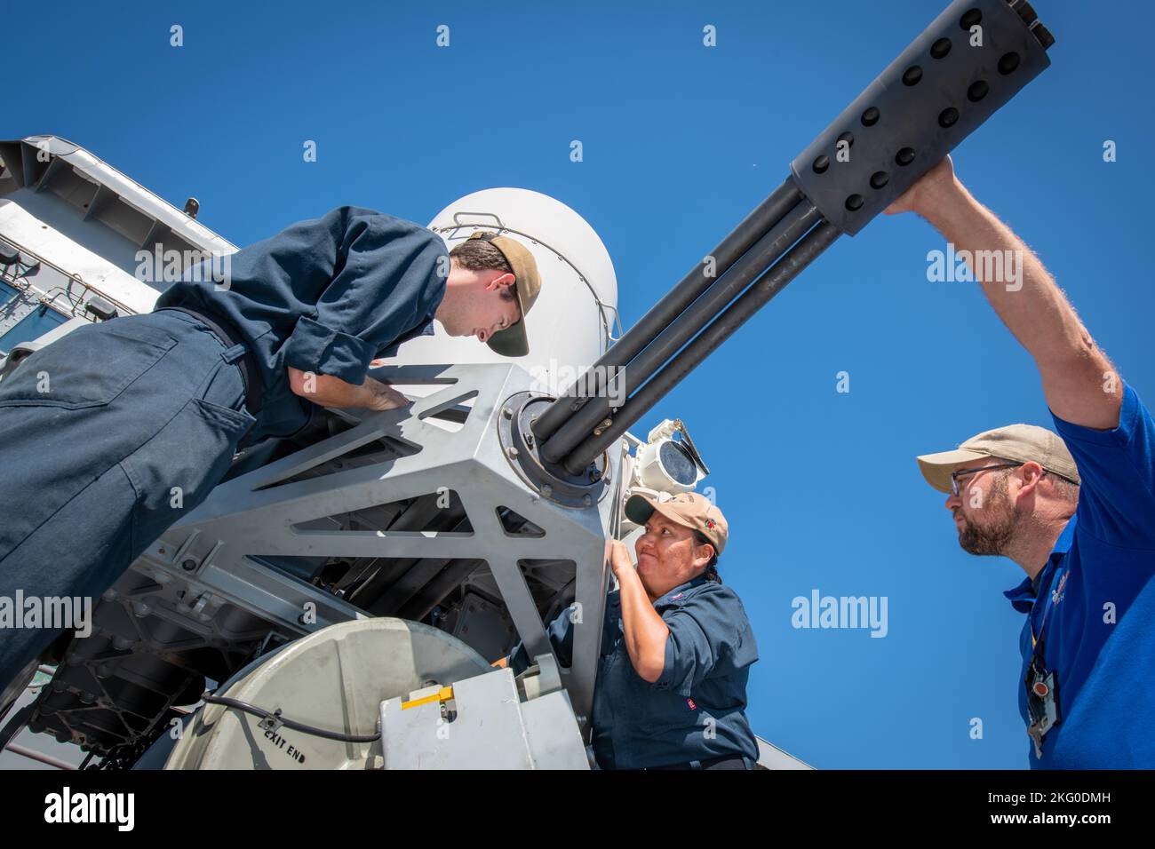 From left: USS Harpers Ferry (LSD 49) Fire Controlman 2nd Class Timothy Rutledge-Murray and Fire Controlman 1st Class Elaine Martine repair the forward Phalanx close-in weapon system (CIWS) under the guidance of Nate Kraft, a field service representative with Naval Surface Warfare Center, Indian Head Division's (NSWC IHD) Picatinny Detachment in Picatinny, New Jersey, during a recent Combat Systems Assessment Team (CSAT) event at NSWC Port Hueneme Division. Kraft traveled from across the country to perform routine maintenance on the CIWS aboard LSD 49. Designed to automatically defend the ship Stock Photo