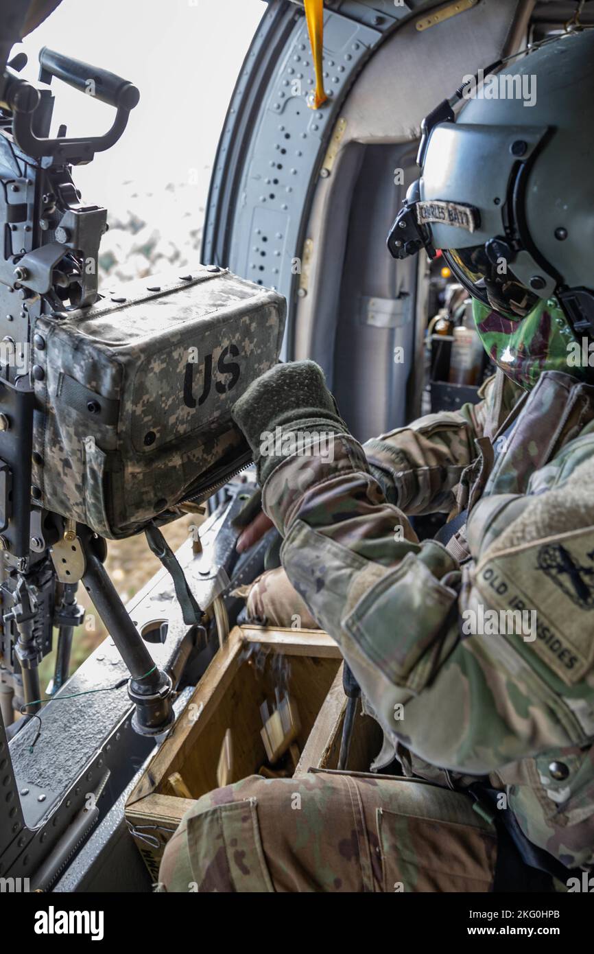 U.S. Army Cpl. John Weber, a UH-60 helicopter maintainer and crew chief assigned to the 3rd Battalion, 501st Aviation Regiment, Combat Aviation Brigade, 1st Armored Division (1AD CAB), empties a M240H machine gun ammo pouch during a live-fire exercise at Drawsko Pomorski, Poland, Oct. 19, 2022. The 1AD CAB is among other units assigned to the 1st Infantry Division, proudly working alongside NATO allies and regional security partners to provide combat-credible forces to V Corps, America's forward deployed corps in Europe. Stock Photo