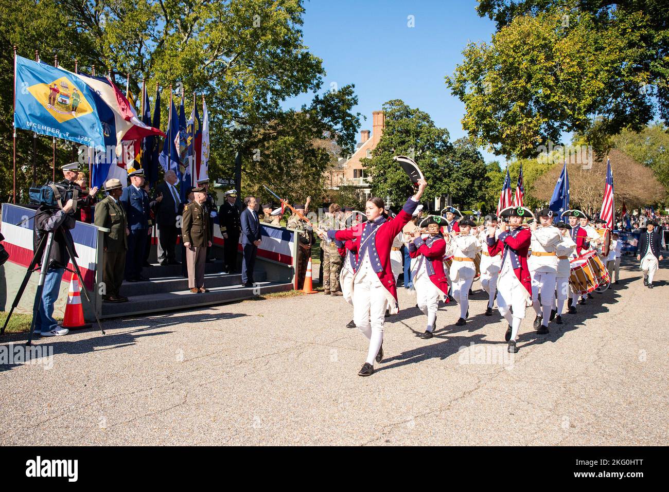 The leader of a fifes and drums unit renders honors to dignitaries in