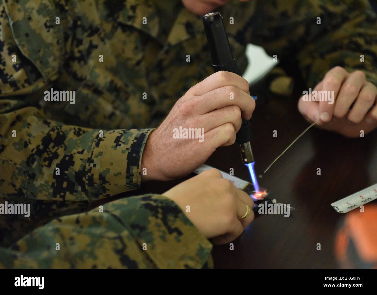 U.S. Marines assigned to Marine Corps Detachment Goodfellow use a modified soldering iron to