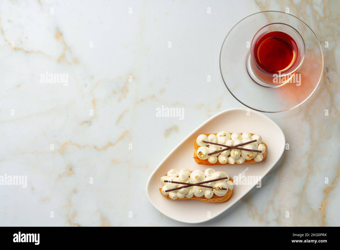 Two eclairs with white custard on whhite plate Stock Photo