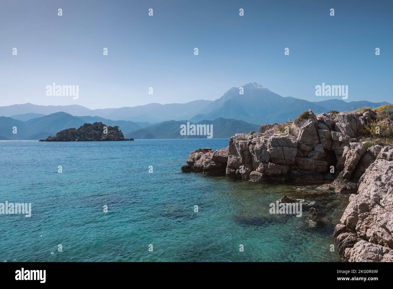 rocky sea shore landscape with distant island and Mt.Tahtali in Antalya province, Turkey Stock Photo