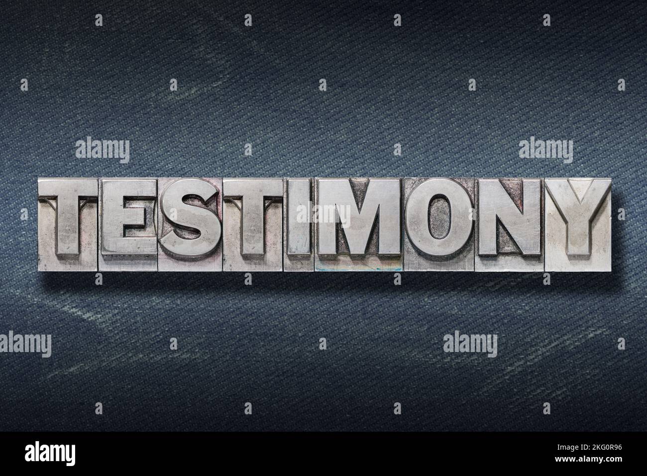 testimony word made from metallic letterpress on dark jeans background Stock Photo