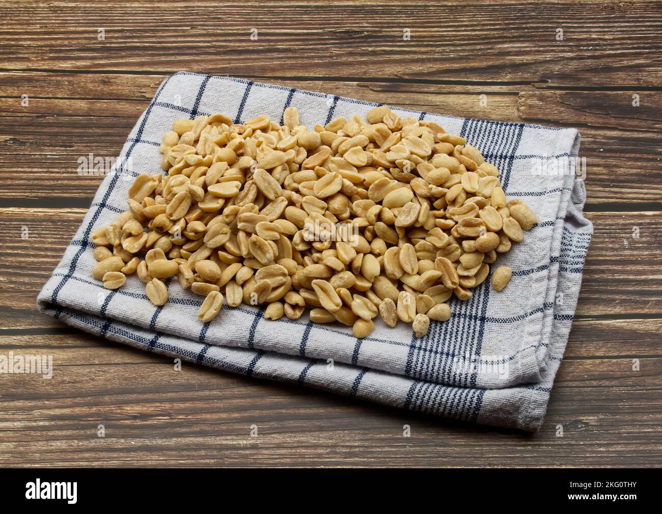 Pealed Peanuts in a bowl isolated on wooden background Stock Photo