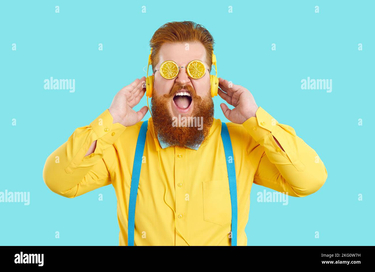 Funny fat man in summer glasses with crazy expression listens to music in headphones. Stock Photo