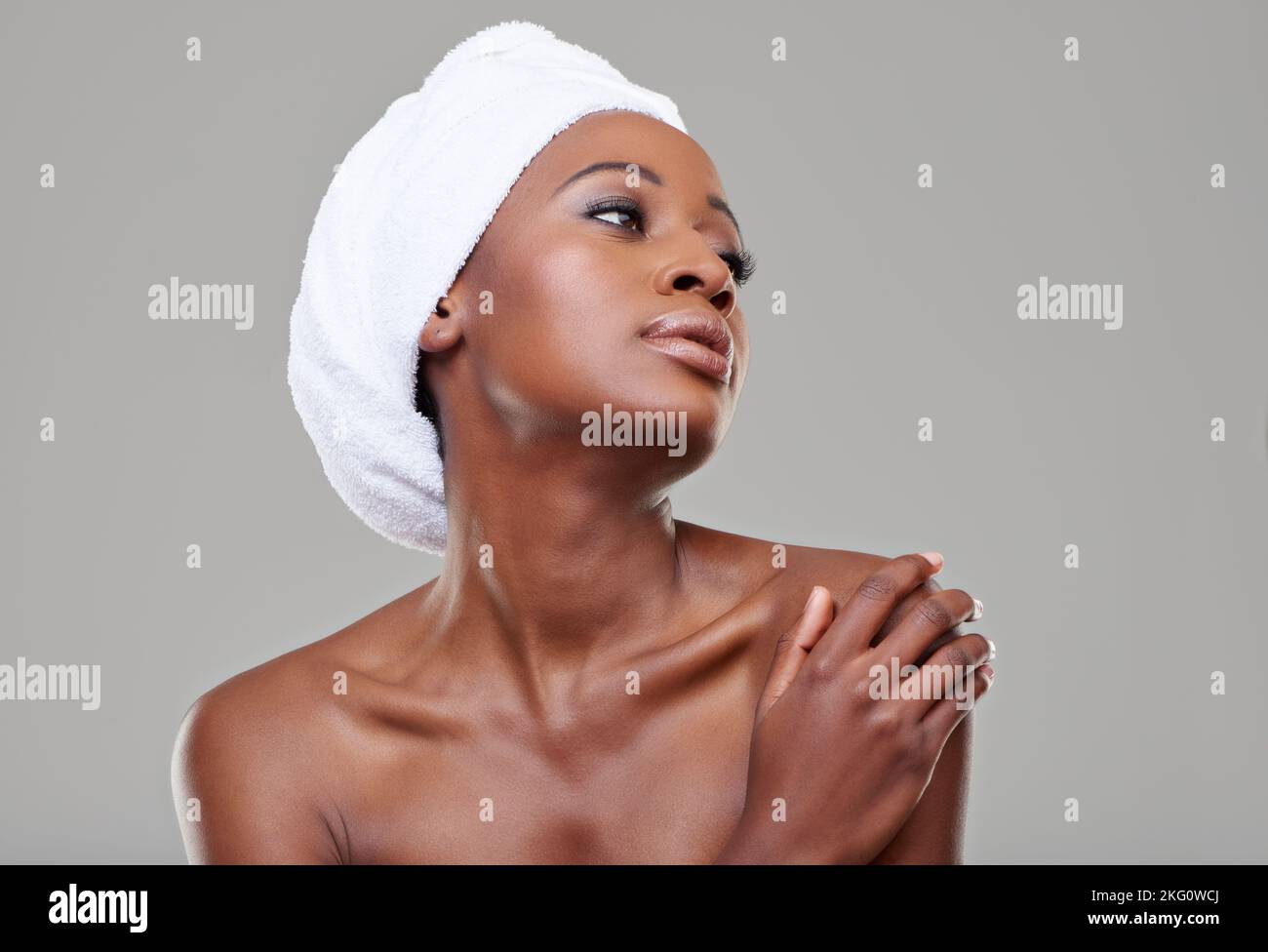 Statuesque beauty. Beauty shot of a young woman with a towel around her head posing in studio. Stock Photo