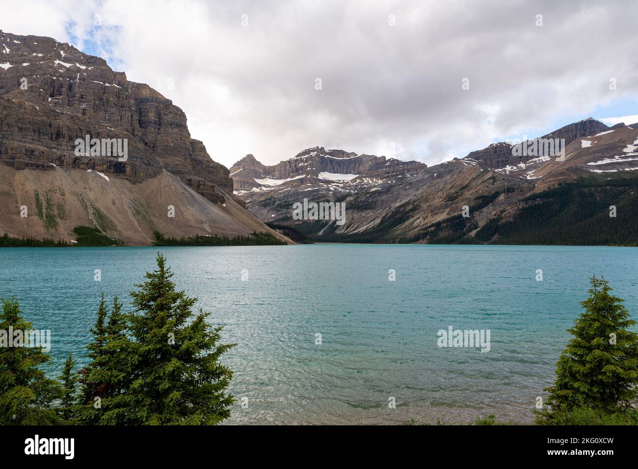 An aerial view of lake surrounded by dense trees and mountains Stock ...