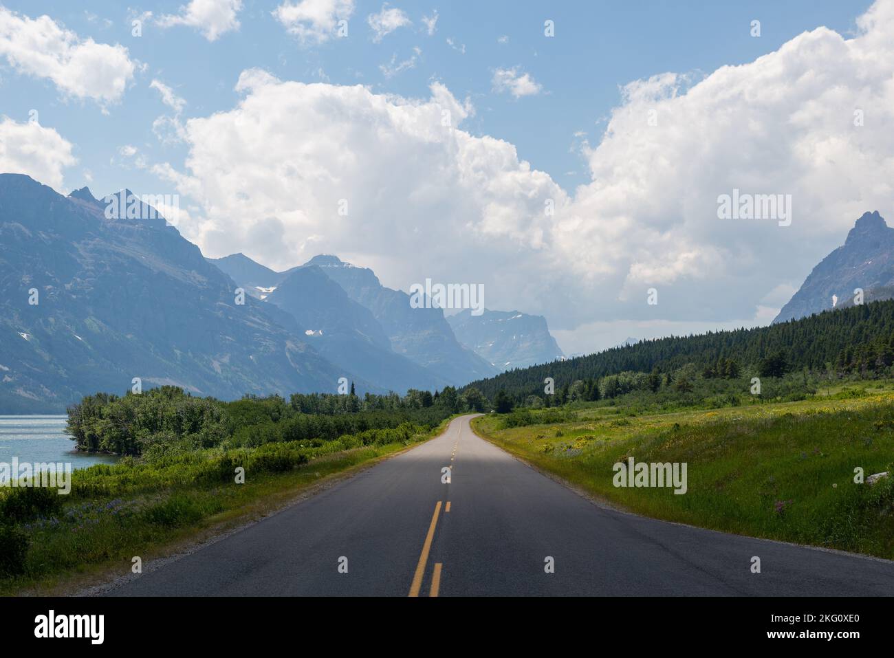 An aerial view of road surrounded by dense trees and mountains Stock ...