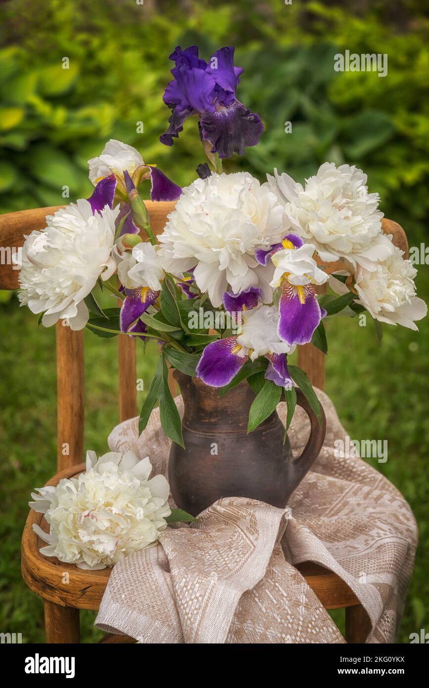 Bouquet of bearded irises and white peonies on a chair Stock Photo Alamy