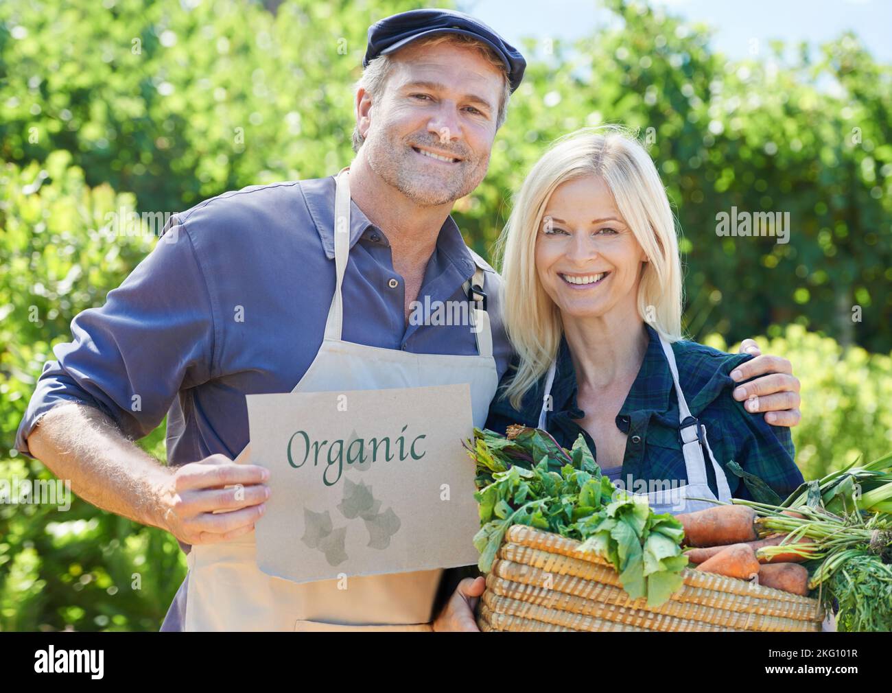 Its all organic. A mature farmer couple holding a basket of freshly picked vegetables. Stock Photo