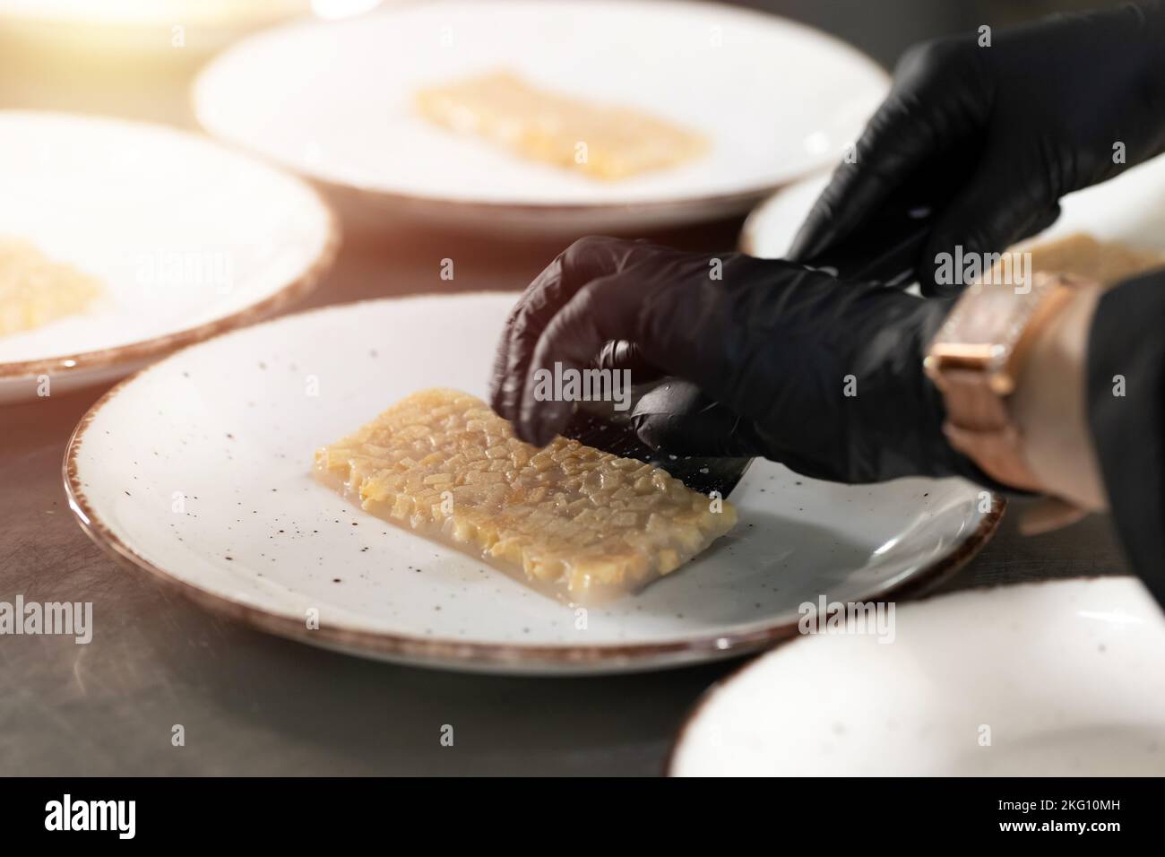 Hand serving a cut of quince jelly in restaurant counter Stock Photo