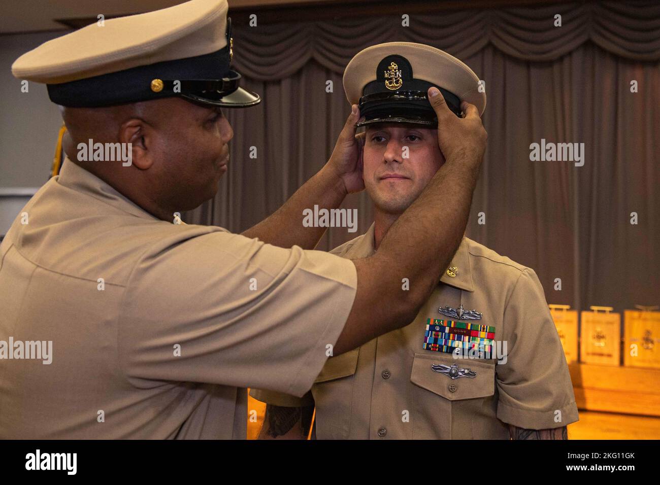 Chief Machinist’s Mate Derek Lipchey, assigned to Surface Warfare School Command Engineering Learning Site Sasebo, receives his combination cover as he is promoted to chief petty officer during a pinning ceremony at Commander, Fleet Activities Sasebo Oct. 21, 2022. The rank of chief petty officer was created April 1, 1893, and the chief petty officer pinning ceremony is a unique tradition to the U.S. Navy that signifies promotion to a crucial position of leadership and responsibility. Stock Photo