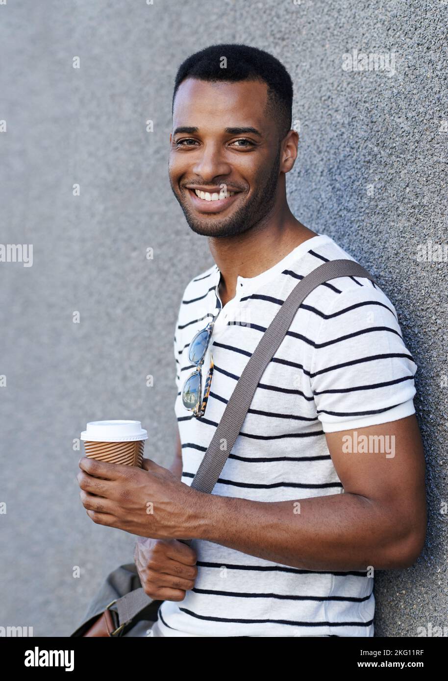 Cuppa Joe on the go. A handsome african american businessman leaning