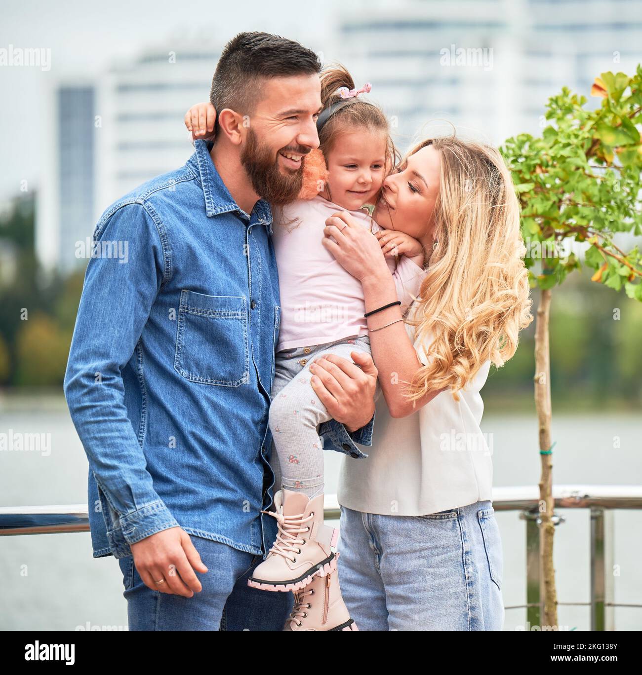 Happy family man and woman with child outdoors. Father holding adorable ...