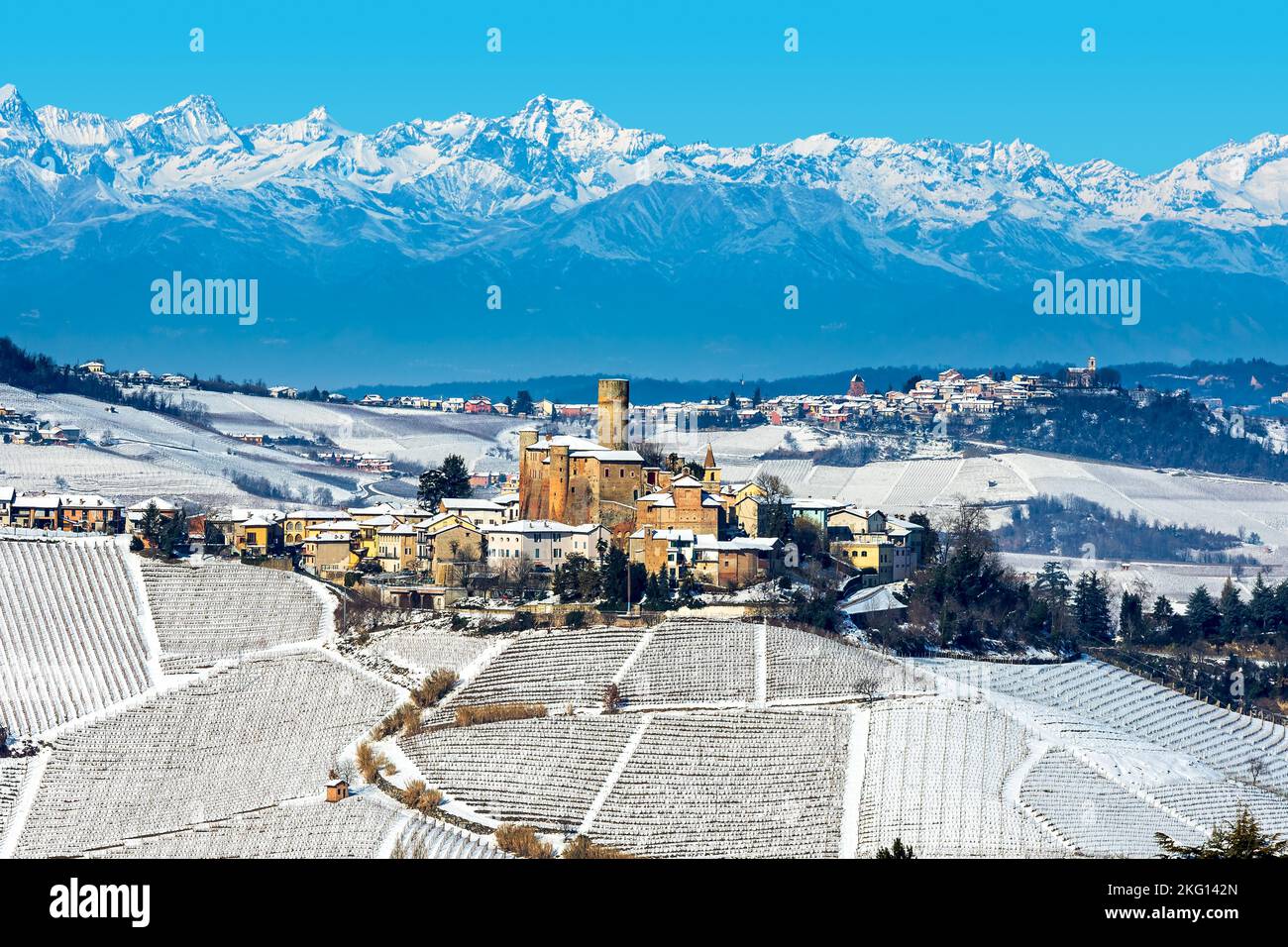View of small medieval town on the hill covered with snow as mountains on background in the winter in Piedmont, Northern Italy. Stock Photo