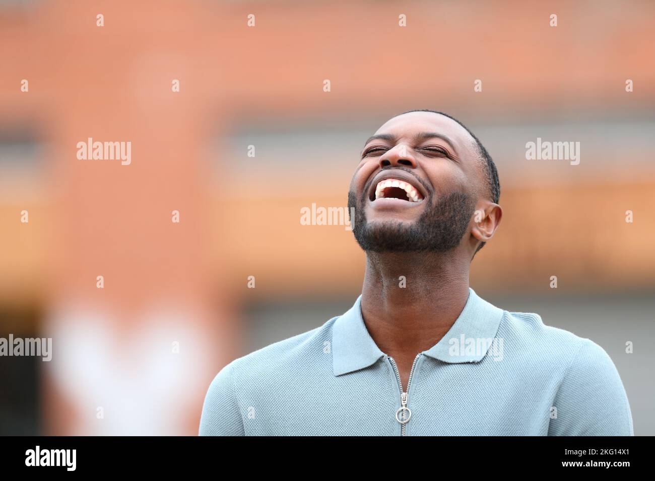 Happy black man laughing loud alone in the street Stock Photo