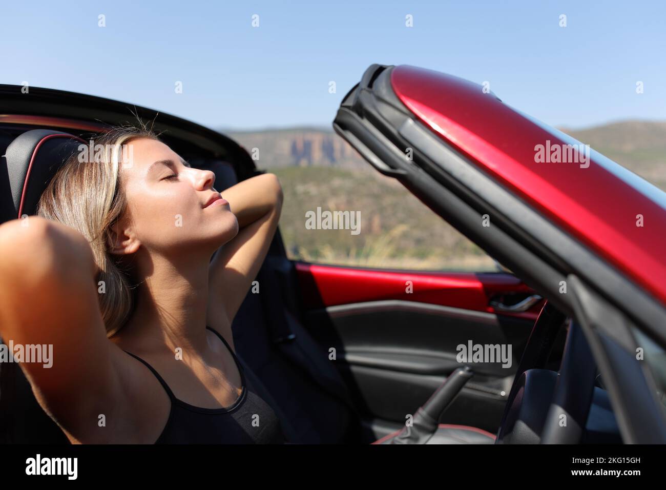 Relaxed driver resting in a convertible car Stock Photo