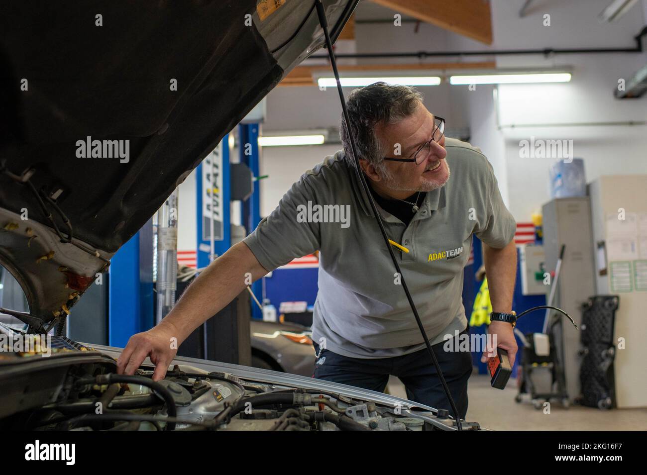 A vehicle safety representative checks the brake fluid of a vehicle