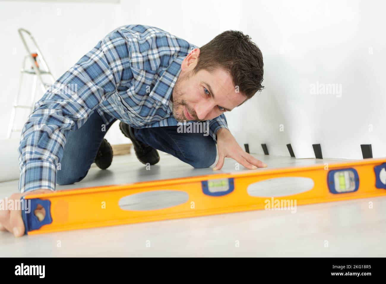 a craftsman measuring floor level Stock Photo Alamy