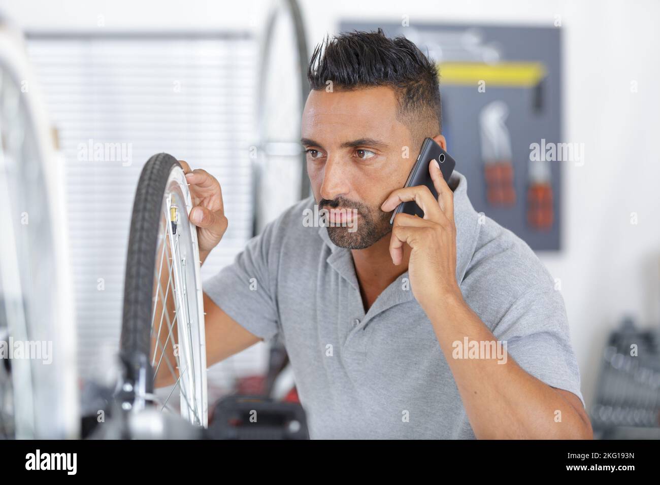 bearded man with bike using his phone Stock Photo