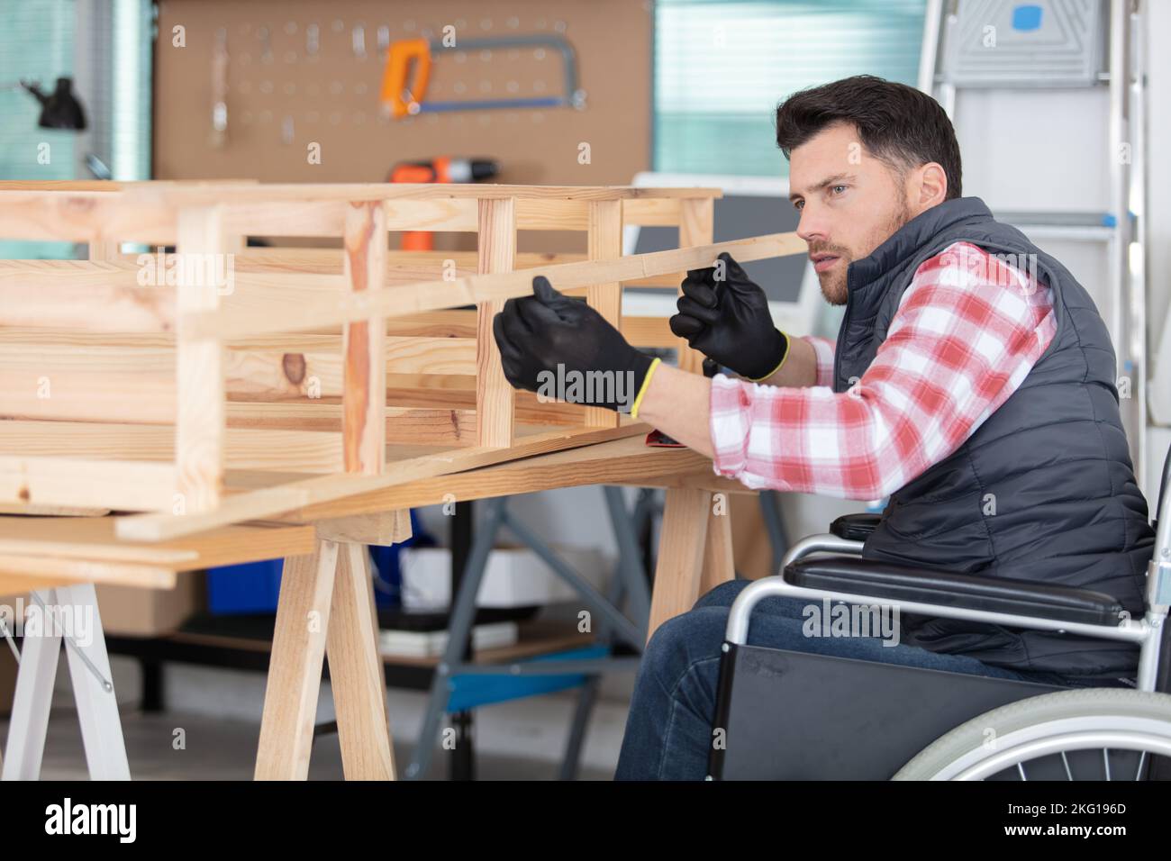 Handicapped Works disabled worker in wheelchair working in wood workshop Stock Photo - Alamy
