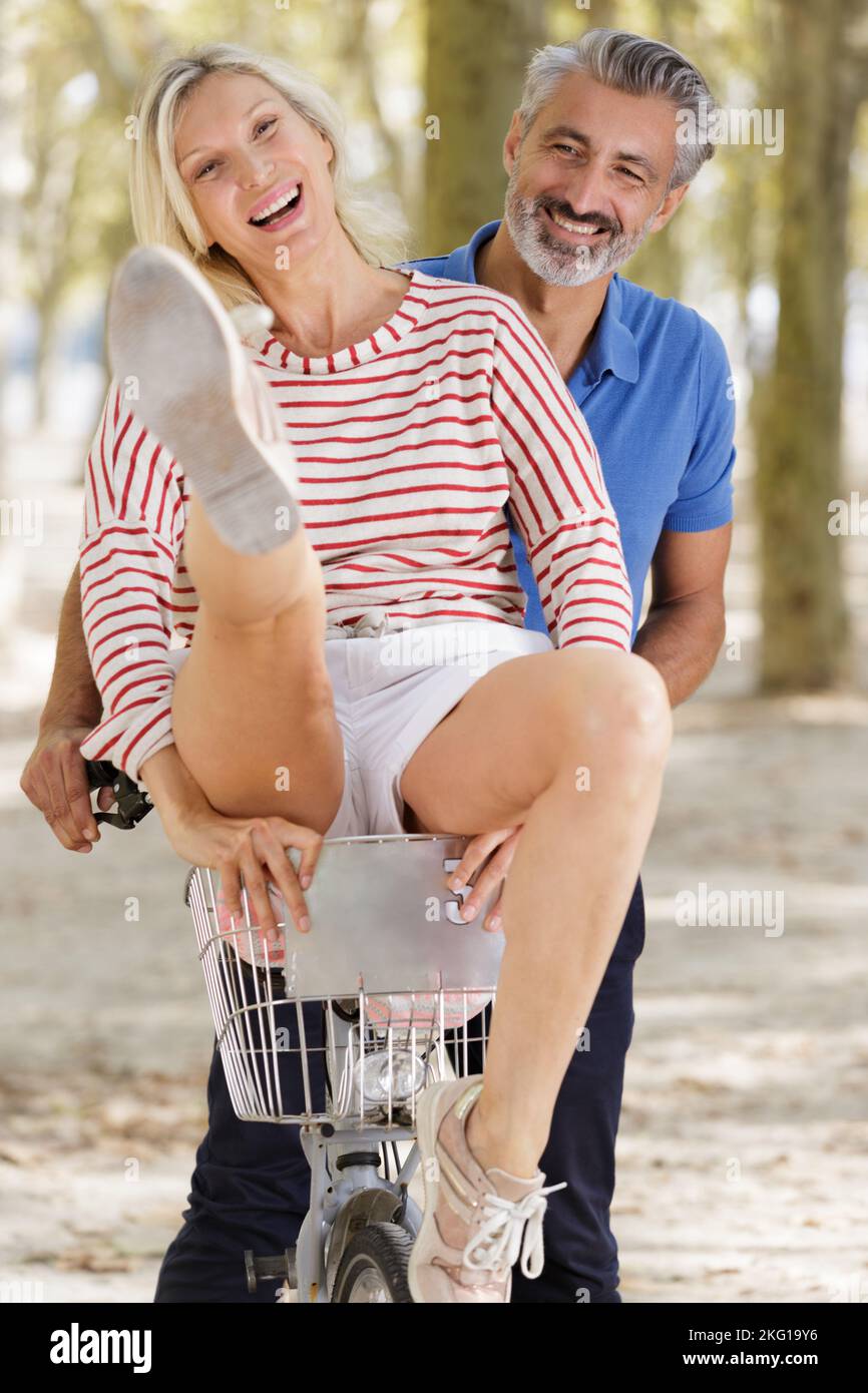 playful mature couple with bikes outdoors Stock Photo