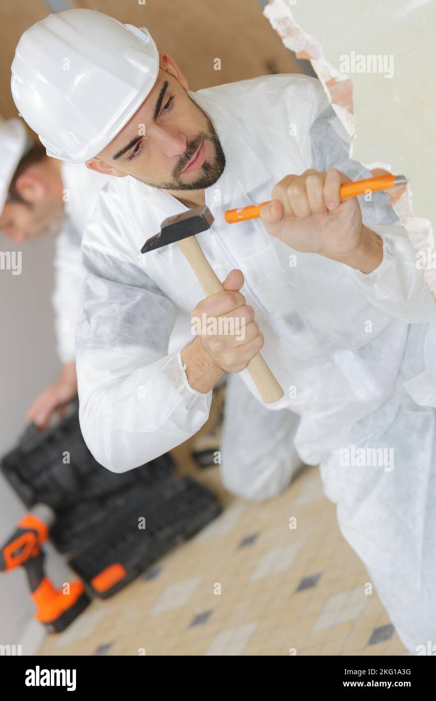 male builder working with a chisel and hammer Stock Photo - Alamy