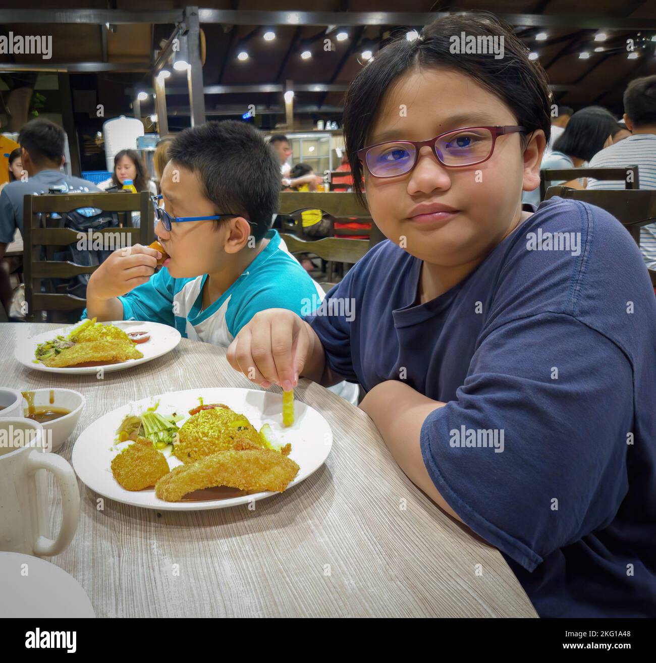 Redang, Malaysia - May 11, 2022: Children eating dinner at the resort