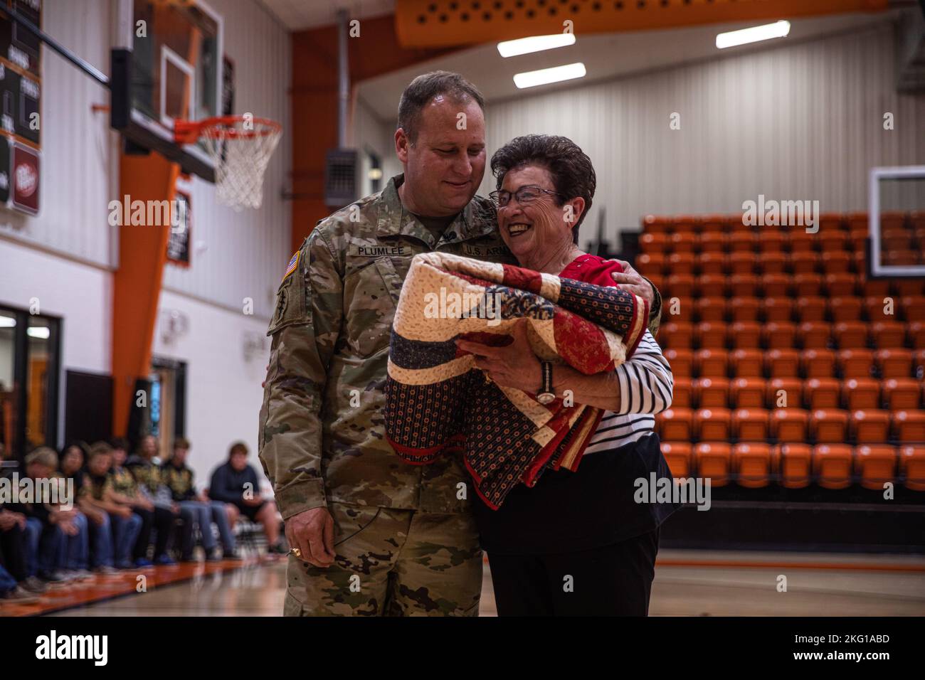 Master Sgt. Earl Plumlee, Medal of Honor recipient, receives a blanket from his former teacher at Merritt High School in Merritt, Oklahoma, Oct. 21, 2022. Plumlee, a native Oklahoman, toured his home state Oct. 18-22. During his visit, Plumlee spoke at a Merritt High School football pep rally about his experiences being a Medal of Honor recipient and what it meant to be back home. (Oklahoma National Guard photo by Sgt. Reece Heck) Stock Photo