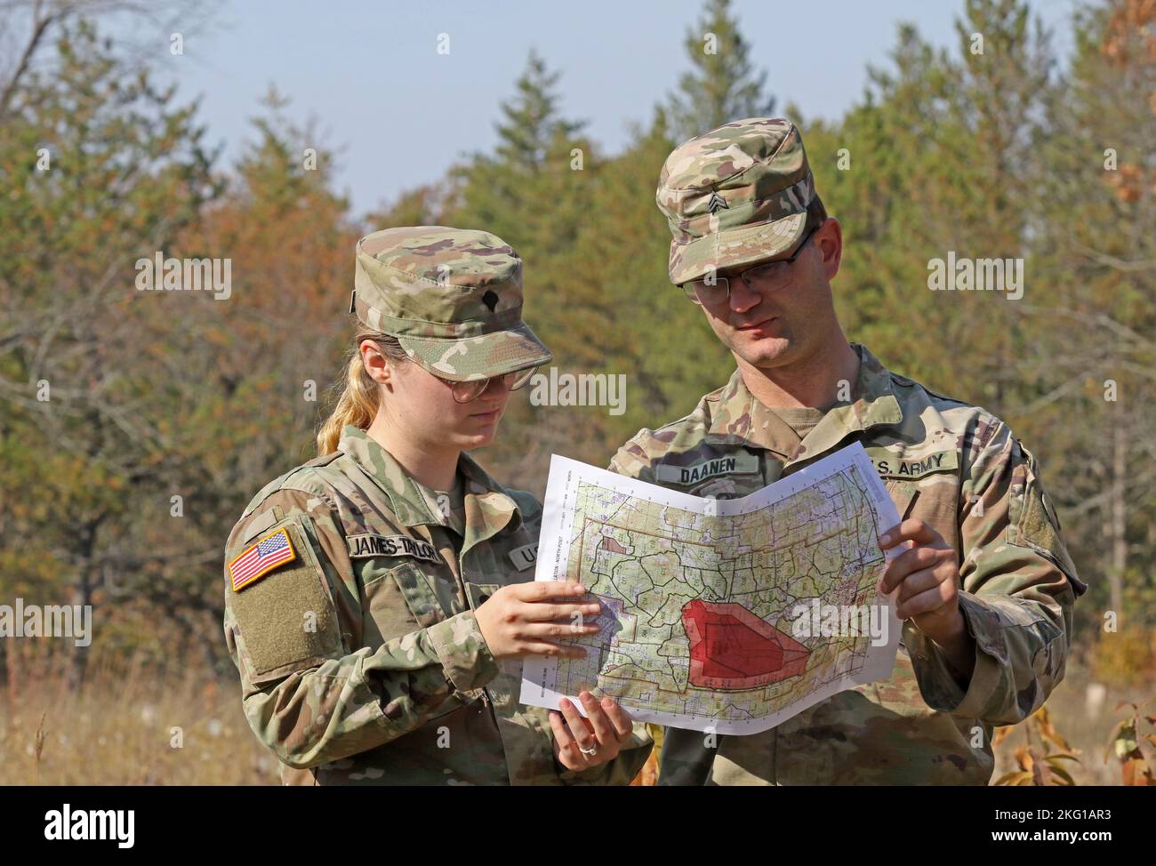 U.S. Army Reserve Spc. Haley James-Taylor and Sgt. Brandon Daanen, both assigned to the 395th Ordnance Company, 103rd Sustainment Command (Expeditionary) based in Appleton, Wis., double check their points on a map during land navigation familiarization training on Fort McCoy, Wis., Oct. 21, 2022. Stock Photo