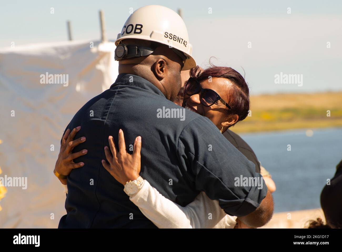 KINGS BAY, Ga. (Oct. 21, 2022) Master Chief Sonar Technician (Submarines) Myron Williams, chief of the boat of the Ohio-class ballistic-missile submarine USS Wyoming (SSBN 742)(Blue) embraces his wife after returning to his homeport of Naval Submarine Base Kings Bay, Georgia, following a routine strategic deterrent patrol that concluded with a tiger cruise. Tiger cruises are an opportunity for Sailors to give friends and family a first-hand experience of life underway aboard a sea-going vessel and experience the ship's day-to-day operations. The base is home to all east coast Ohio-class submar Stock Photo