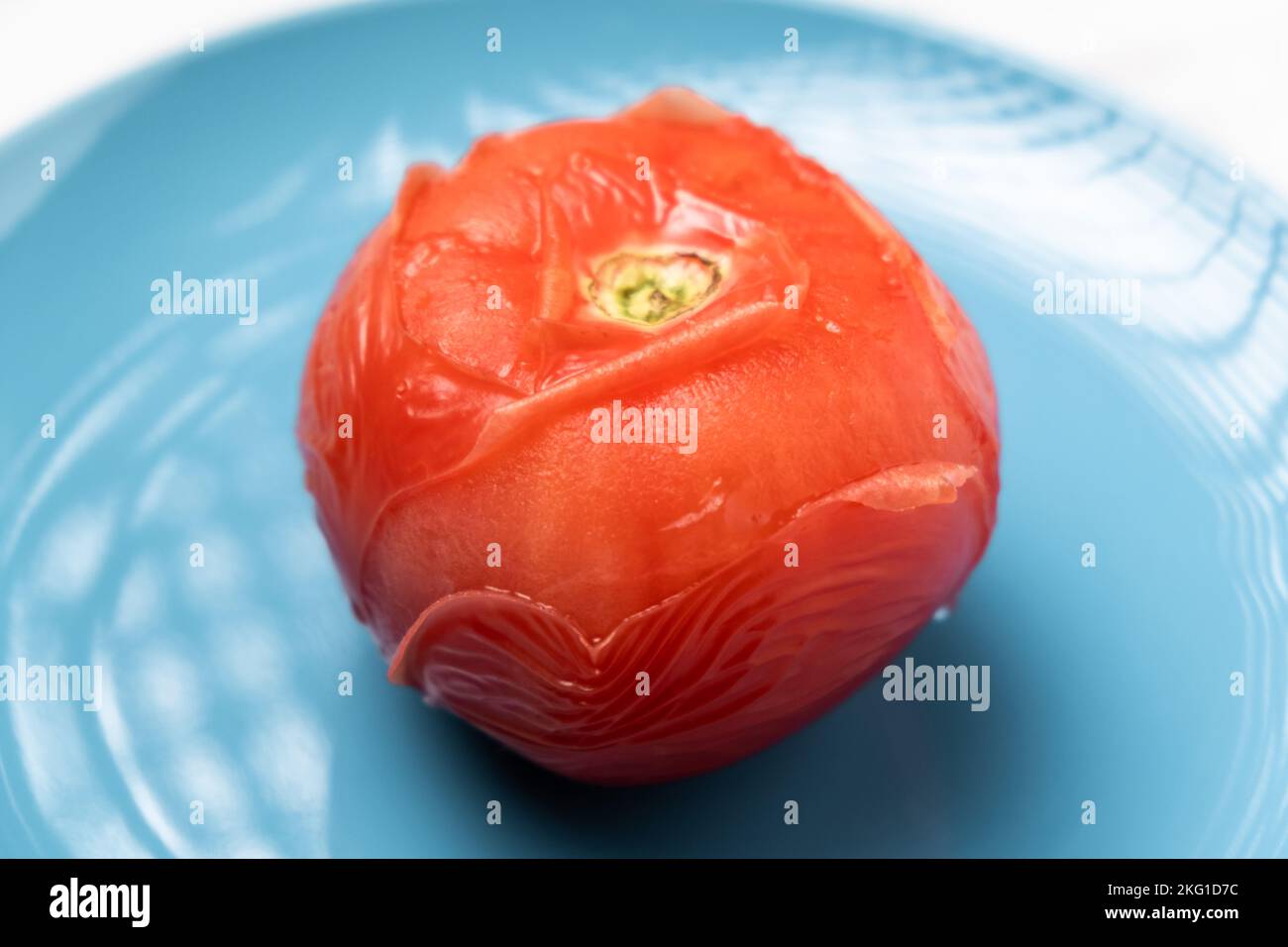 Peeling tomatoes in boiling water. Tomato after being in hot water