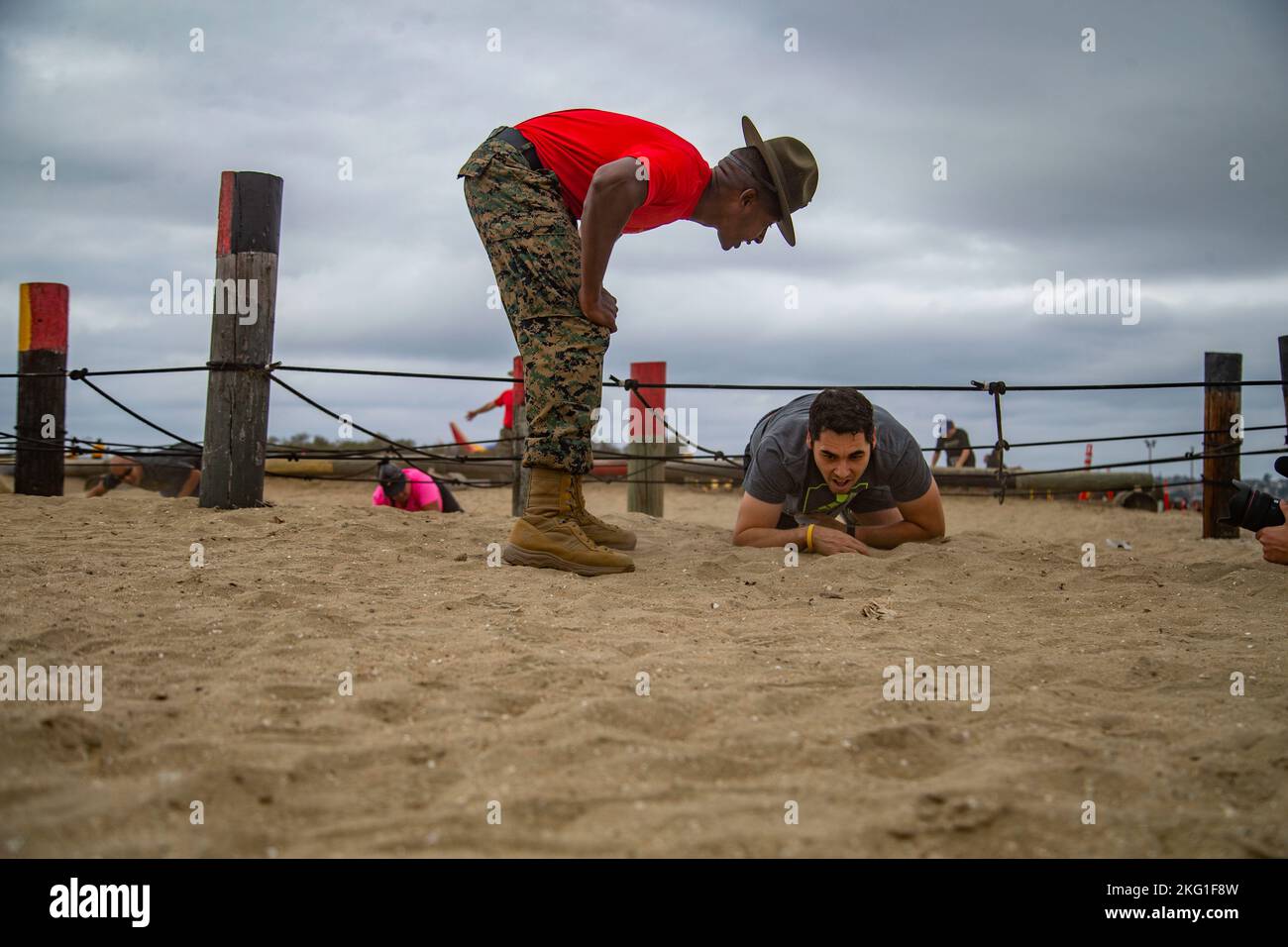 A Boot Camp Challenge participant low crawls at Marine Corps Recruit ...