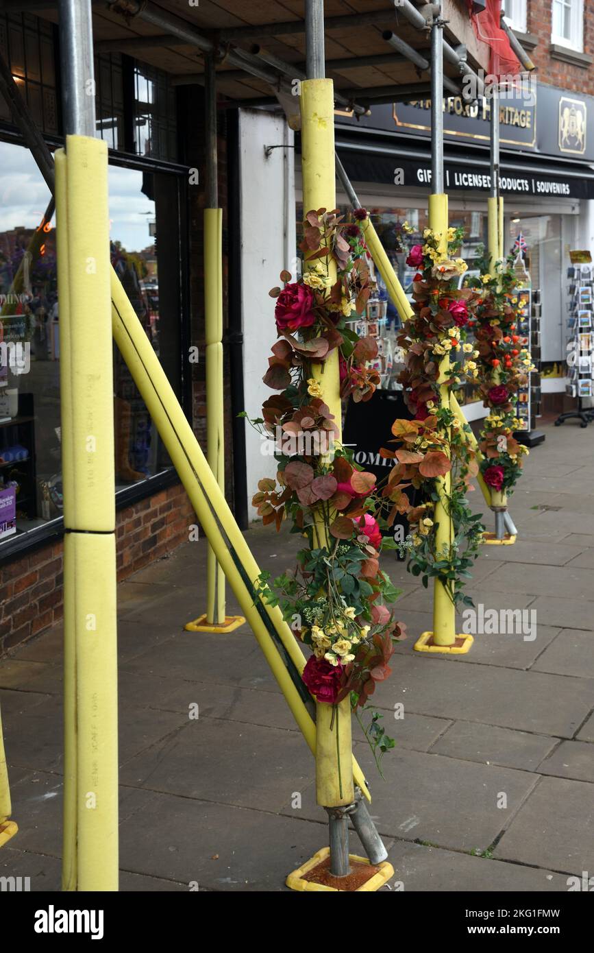 Scaffolding Protected with Flexible Elastomeric Foam Tubes and Decorated with Articitial Flowers Stock Photo