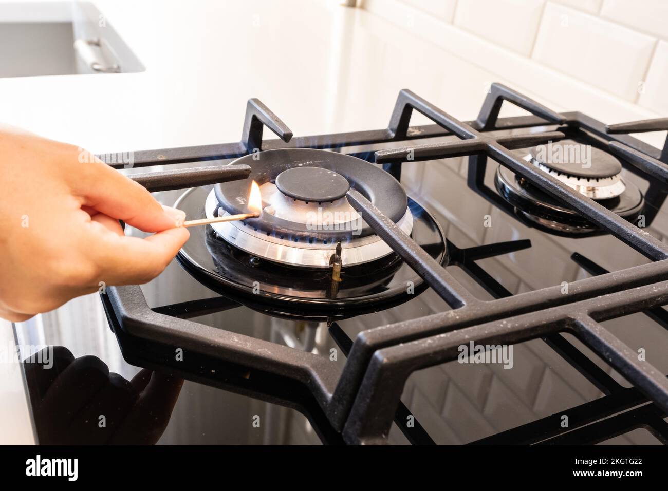 Hand turns on the gas burner on the gas stove Stock Photo Alamy