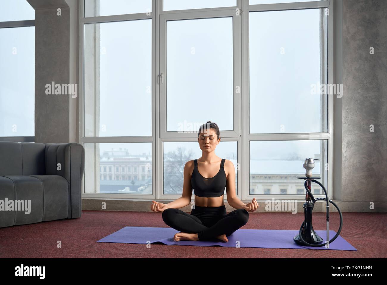 Beautiful young girl in colour yoga wear in the room Stock Photo