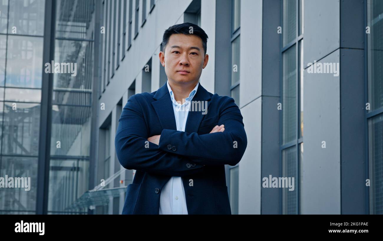 Portrait confident strong pose motivated successful 40s Asian man trader entrepreneur businessman boss leader employer crossing hands posing near Stock Photo