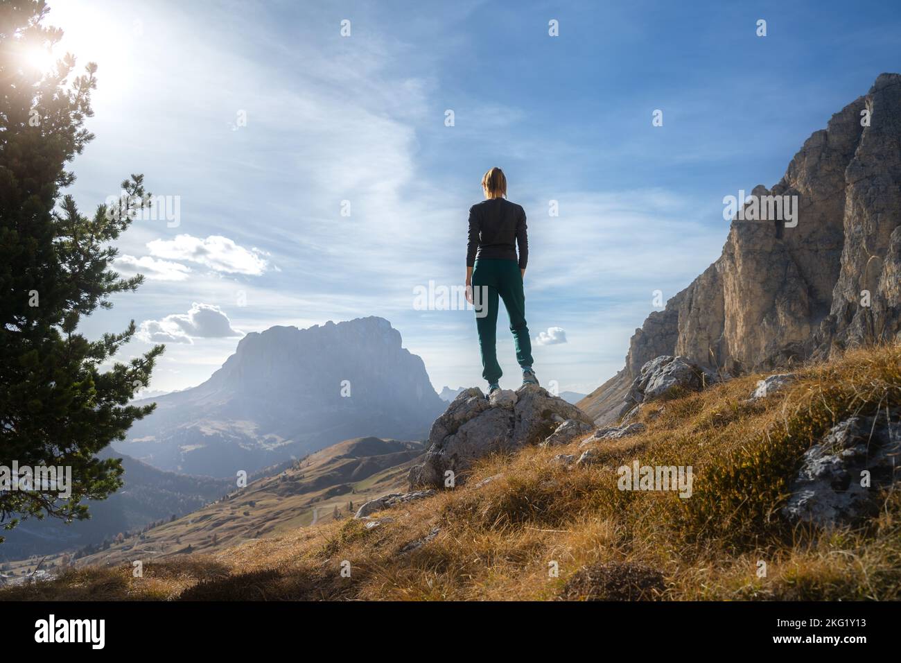 Woman on the stone on mountain trail at sunset in autumn Stock Photo