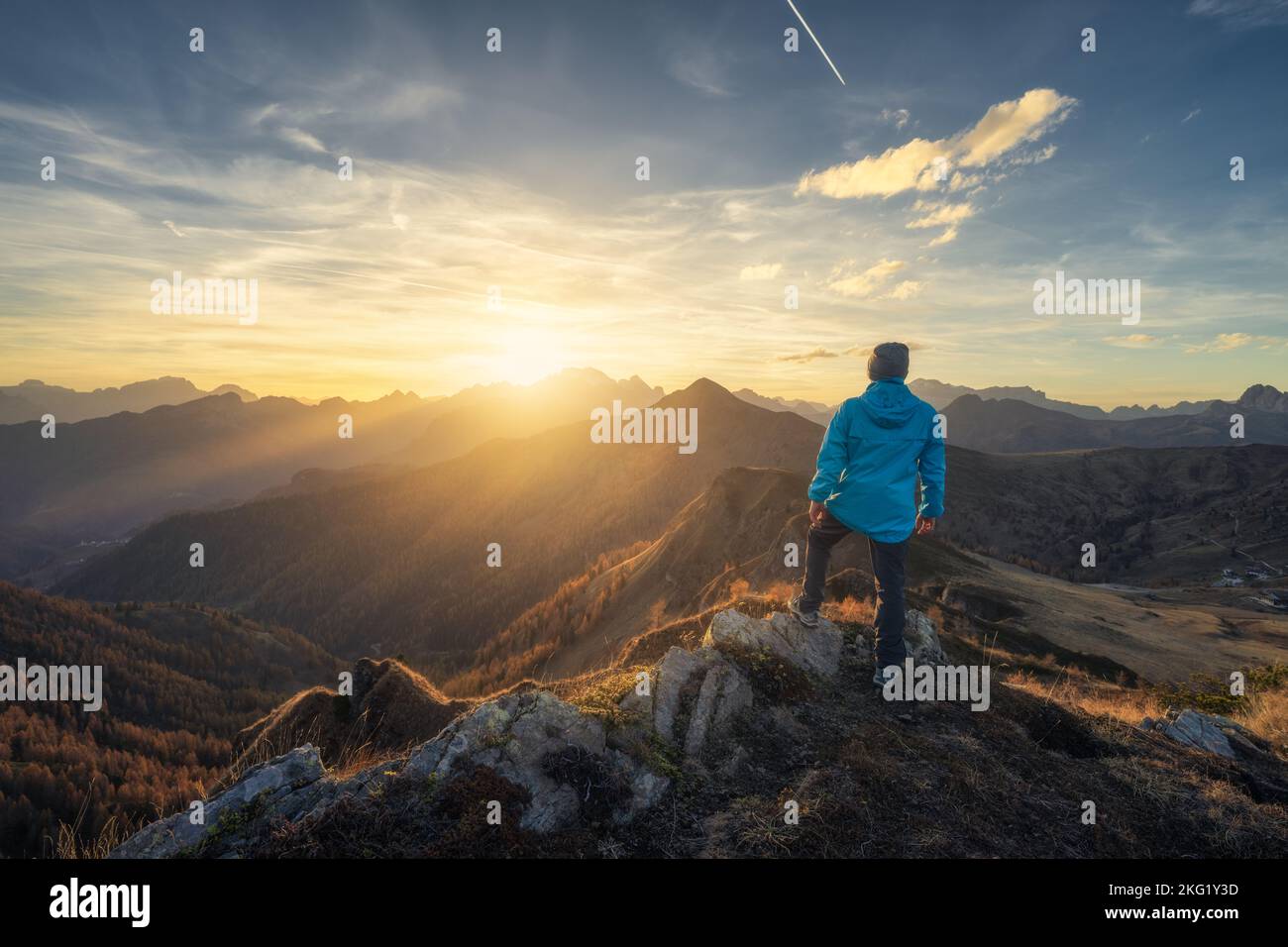 Man on stone on the hill and beautiful mountains in haze Stock Photo